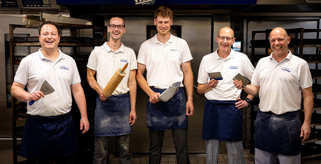Het bakkersteam van Van Hassel voor de oven met gereedschap in de hand