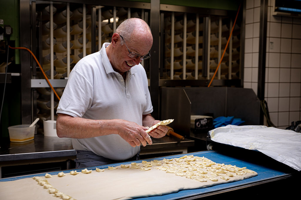Een van de bakkers van Van Hassel werkt geconcentreerd aan de banketgebakken
