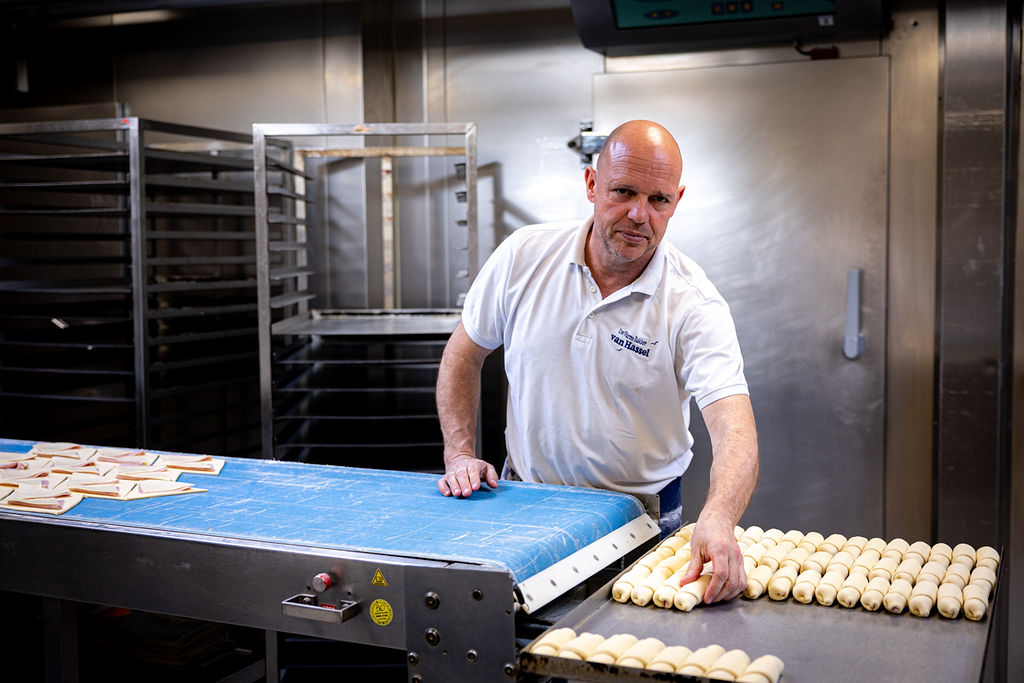 Bakkers aan het werk met verse croissants op de band